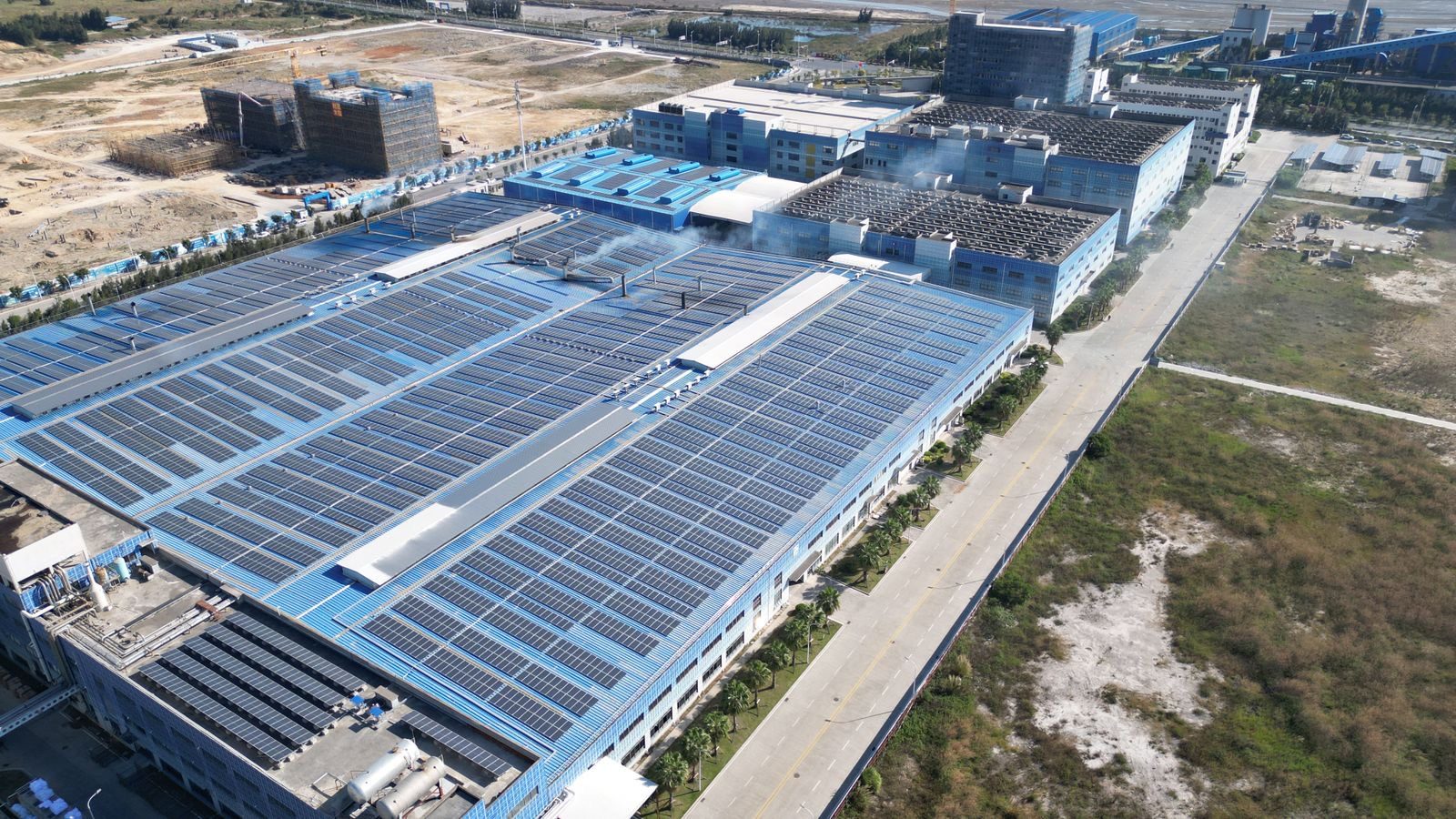 Aerial view of multiple commercial rooftops across an estate covered with solar panels