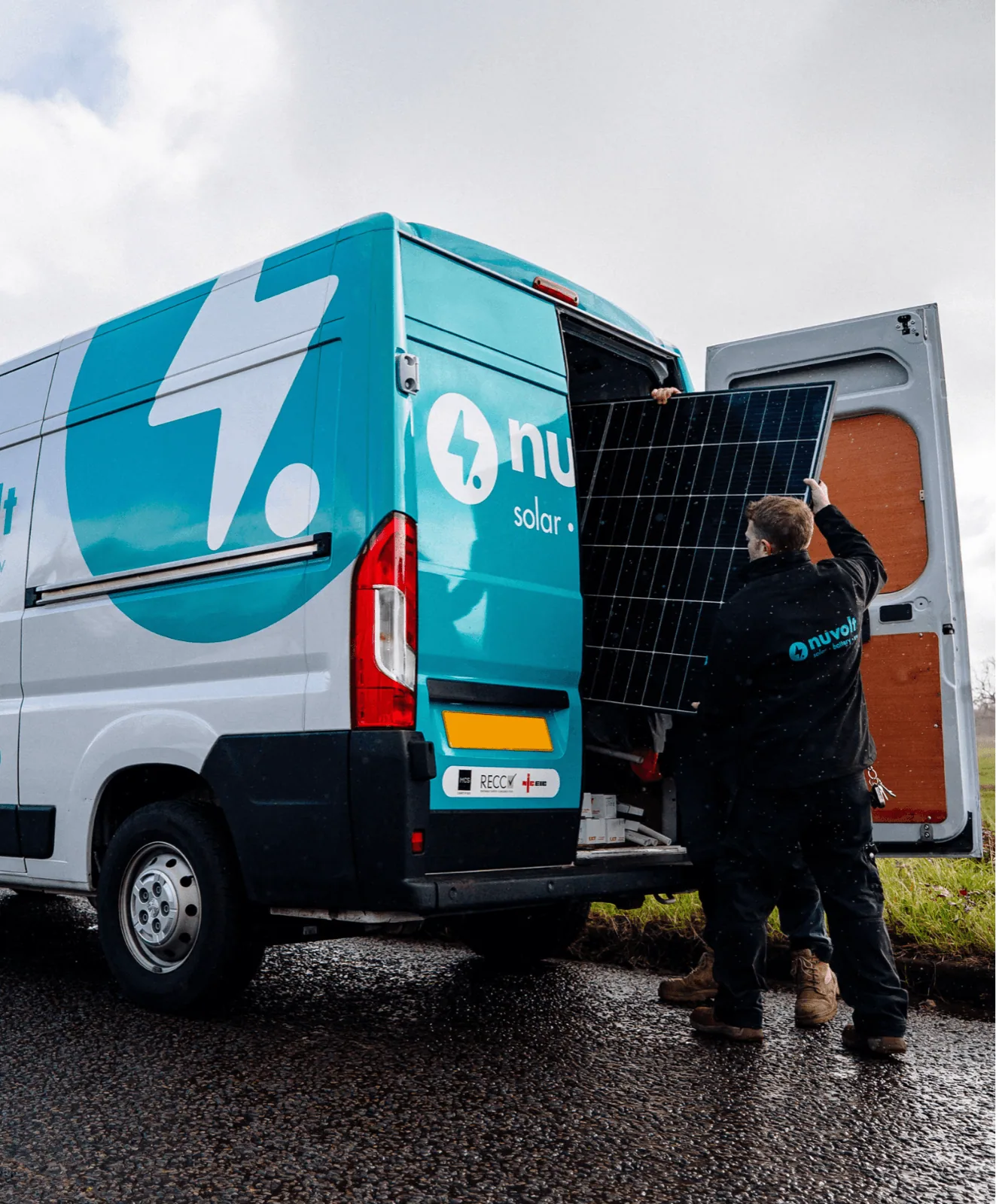 Nuvolt engineers loading a solar panel from a branded service van — UK-wide commercial energy delivery