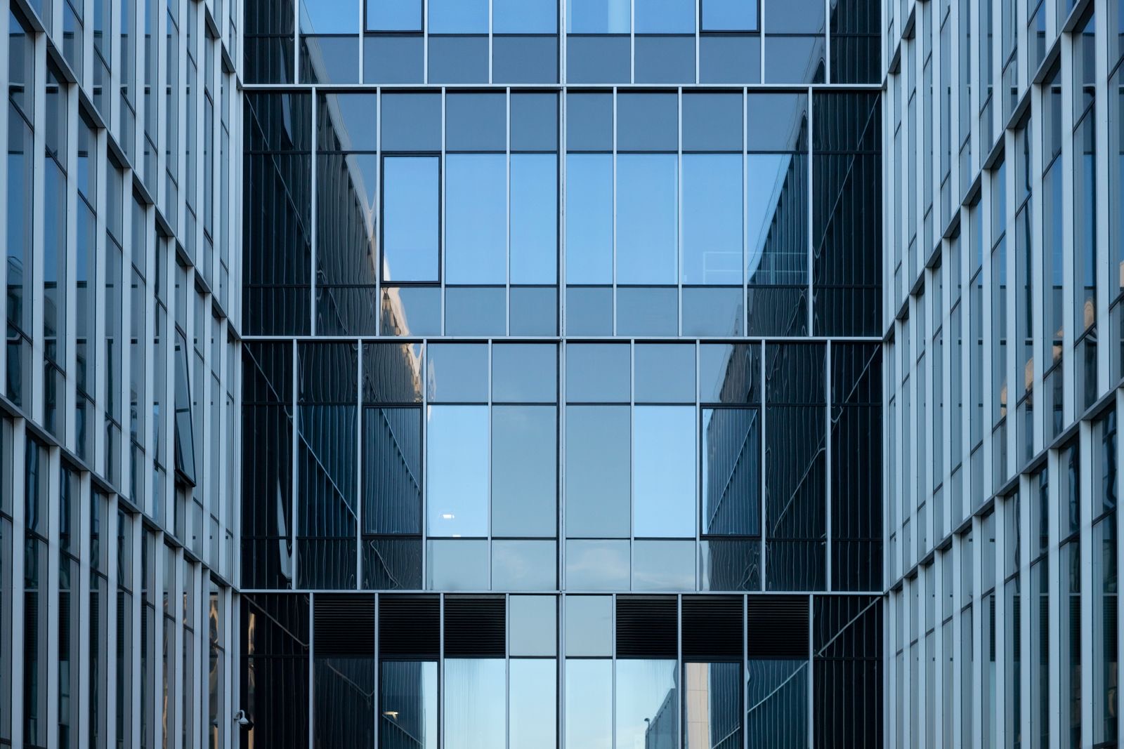 The glass facade of a modern corporate office building