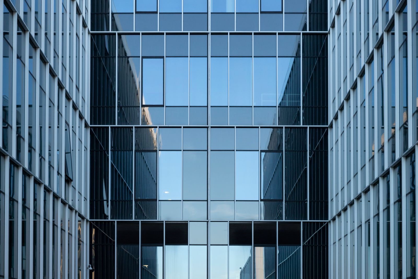 The glass facade of a modern corporate office building